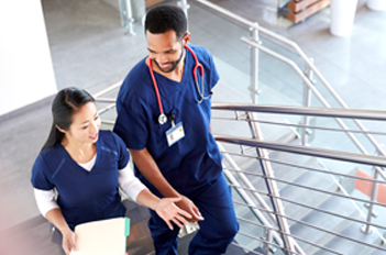 Healthcare workers talking while using the stairs.
